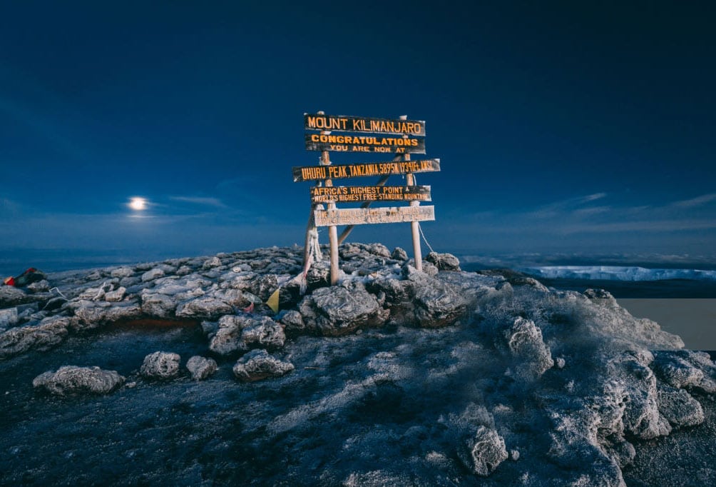 Full moon lighting up the sky over Kilimanjaro peak's signage
